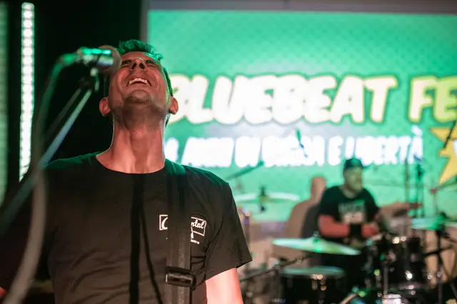 Maurizio singing in front of the screen at Bluebeat Fest